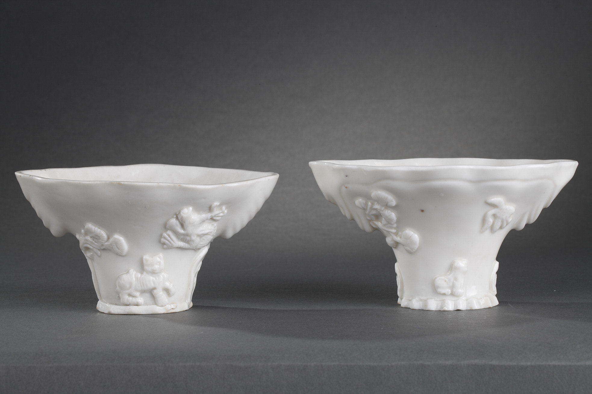 Pair of "blanc de Chine" rhinoceros horn shaped cups with animals decoration like: tiger dragon deer or crane
